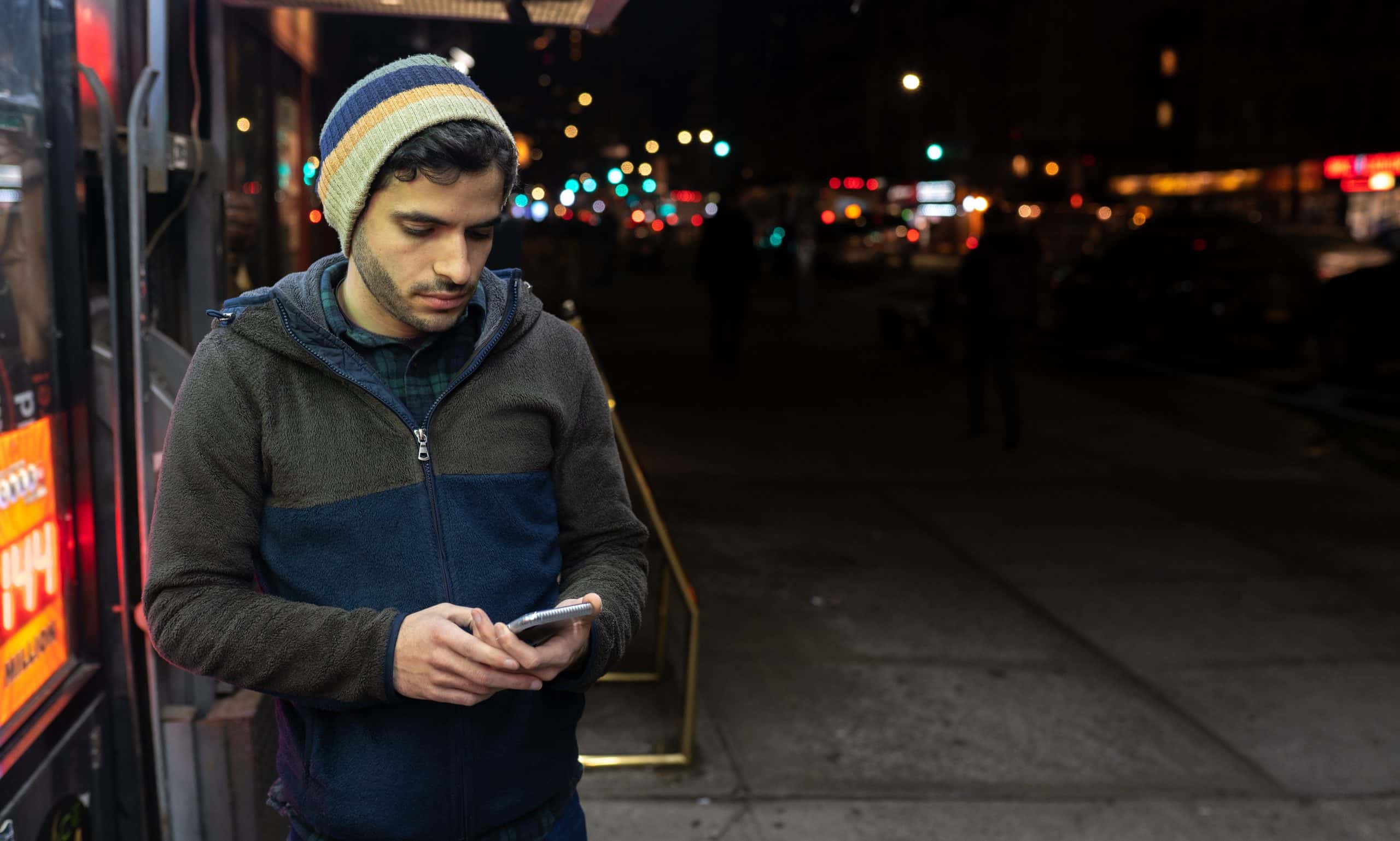 Man looking at his phone at night.