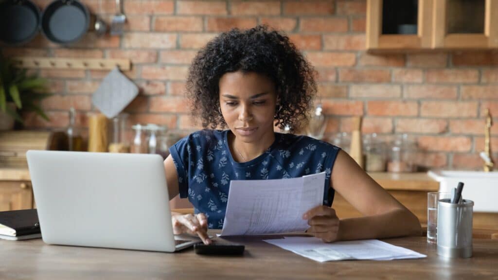 Woman sitting at a table paying bills.