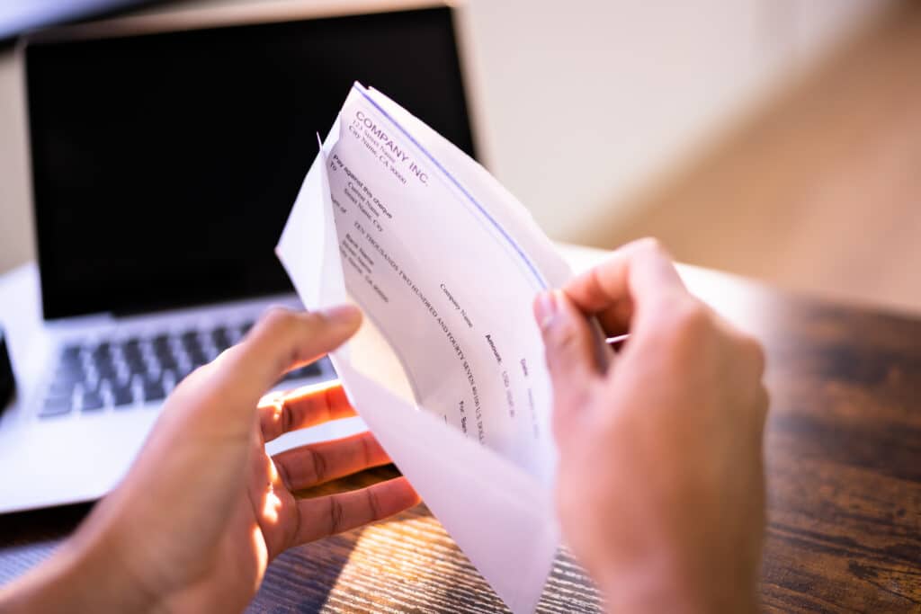 Person pulling their paycheck out of an envelope