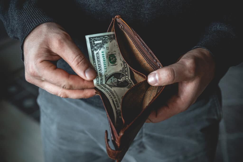 An empty wallet in the hands of a young man