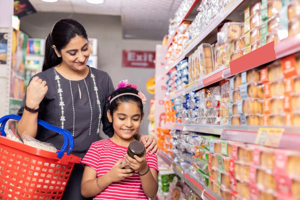 brand name vs generic. Woman and daughter standing in a grocery store aisle.