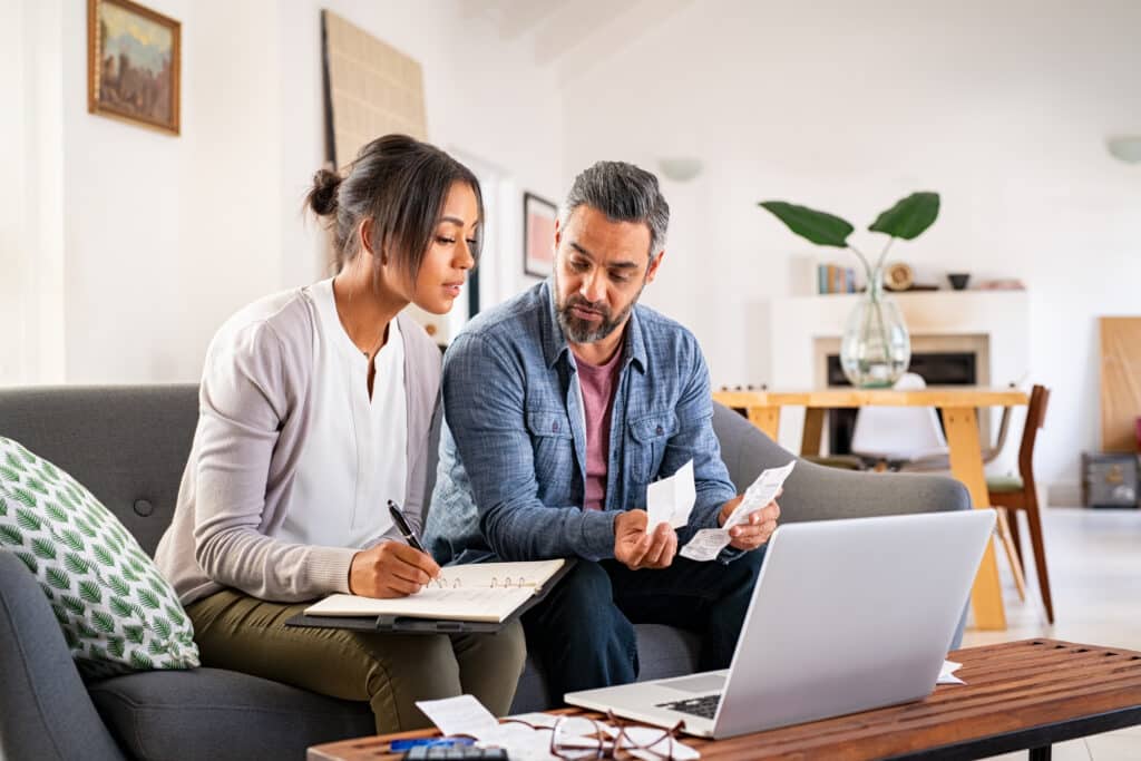 couple sitting on couch demonstrating how to analyze your spending