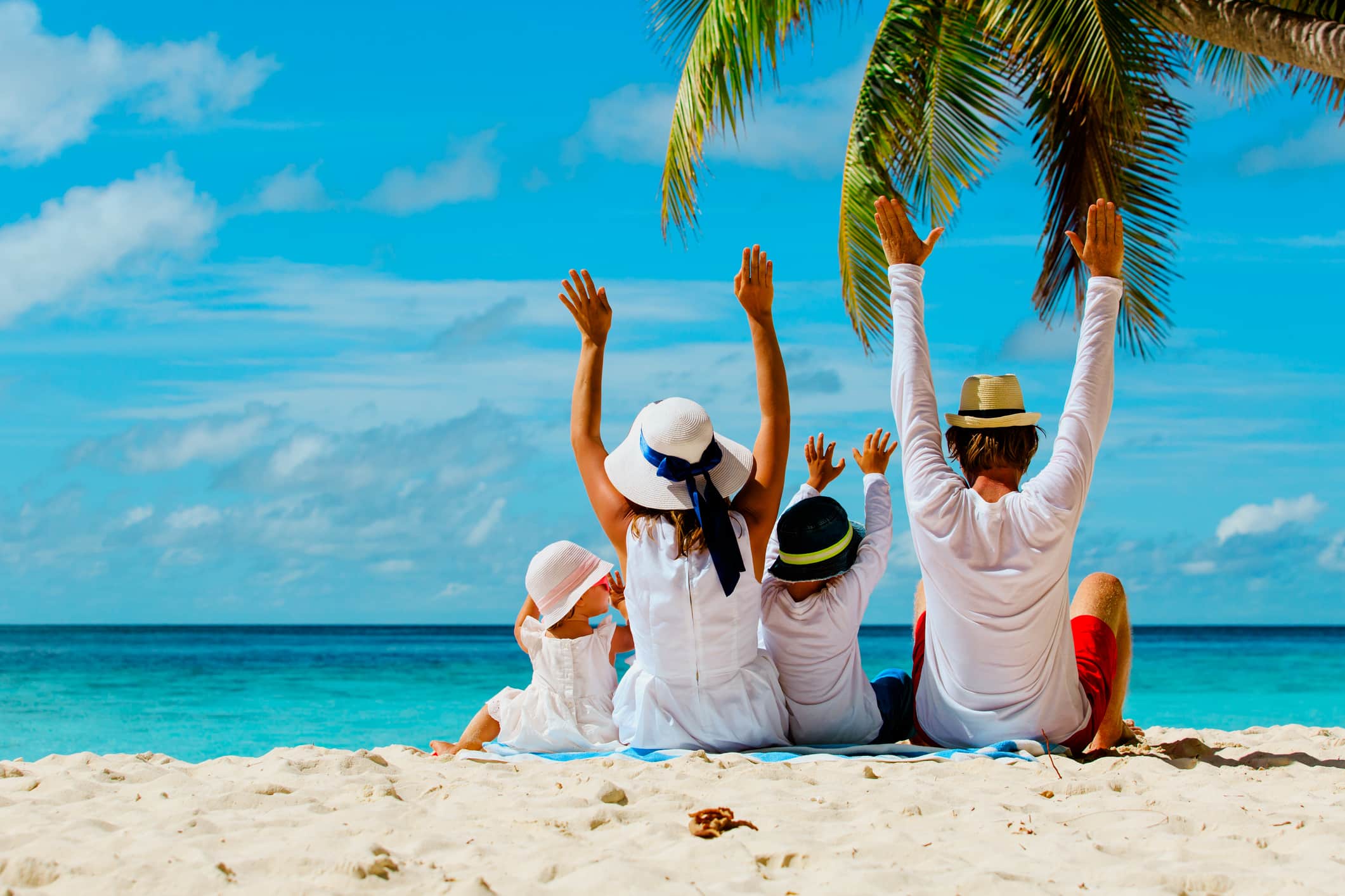 tropical family vacations example, happy family with two kids hands up on tropical beach