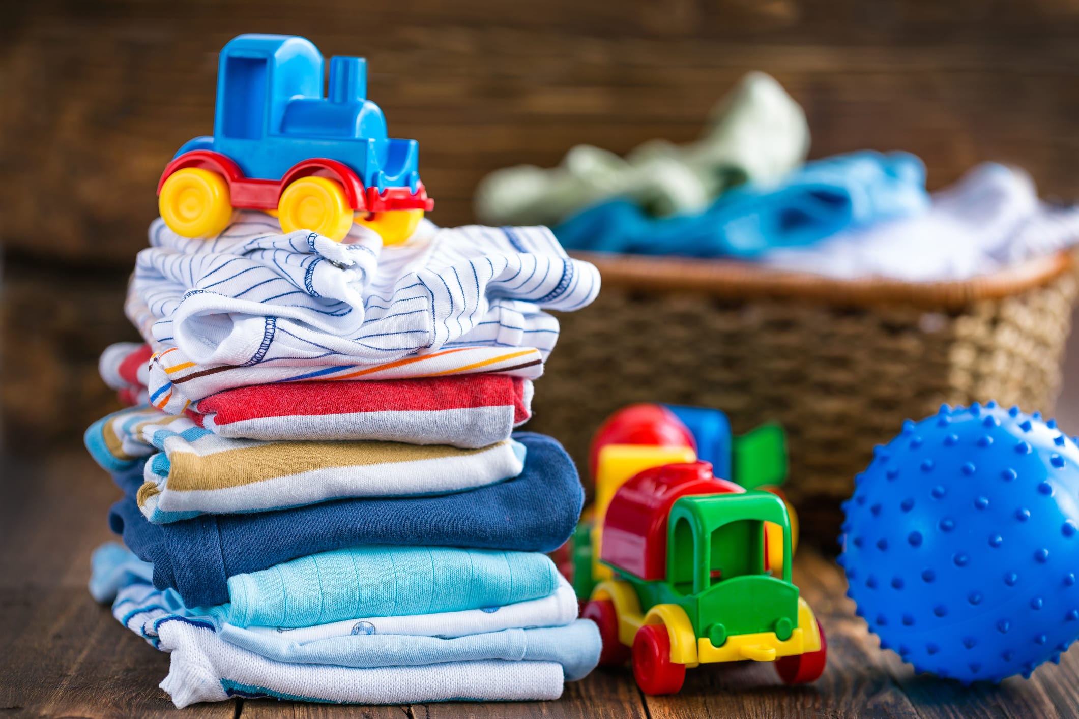 kids clothing on a budget. stack of folded clothes with a toy truck.