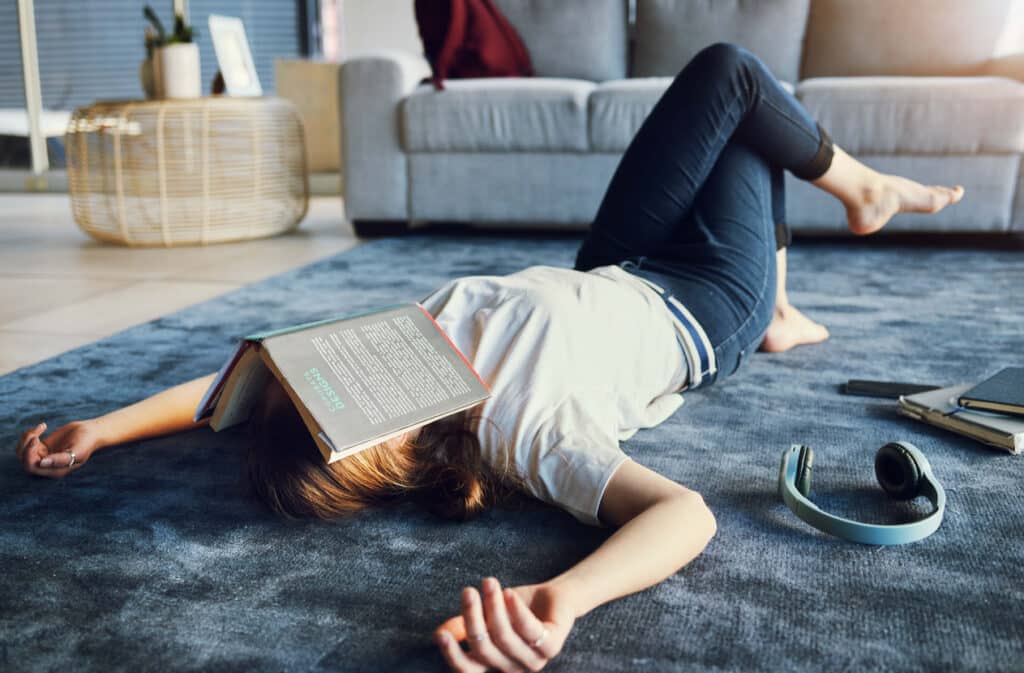 Woman on the ground with a book on her face