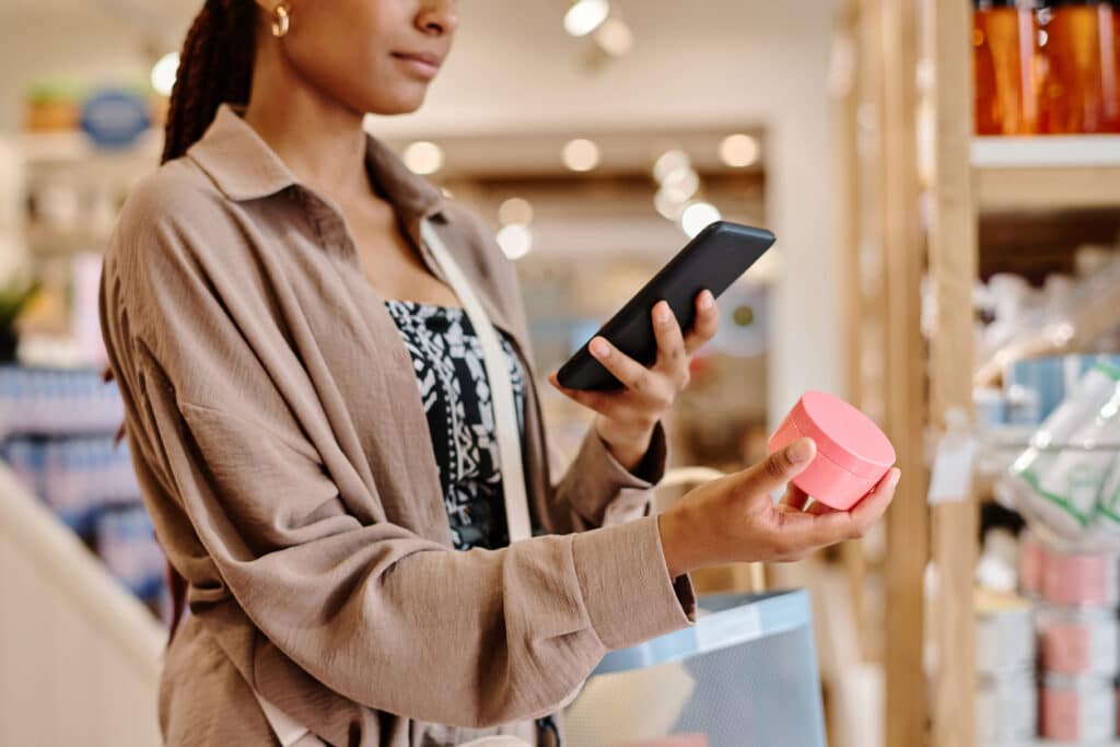 affordable beauty products. woman lookin gat a jar in a store.