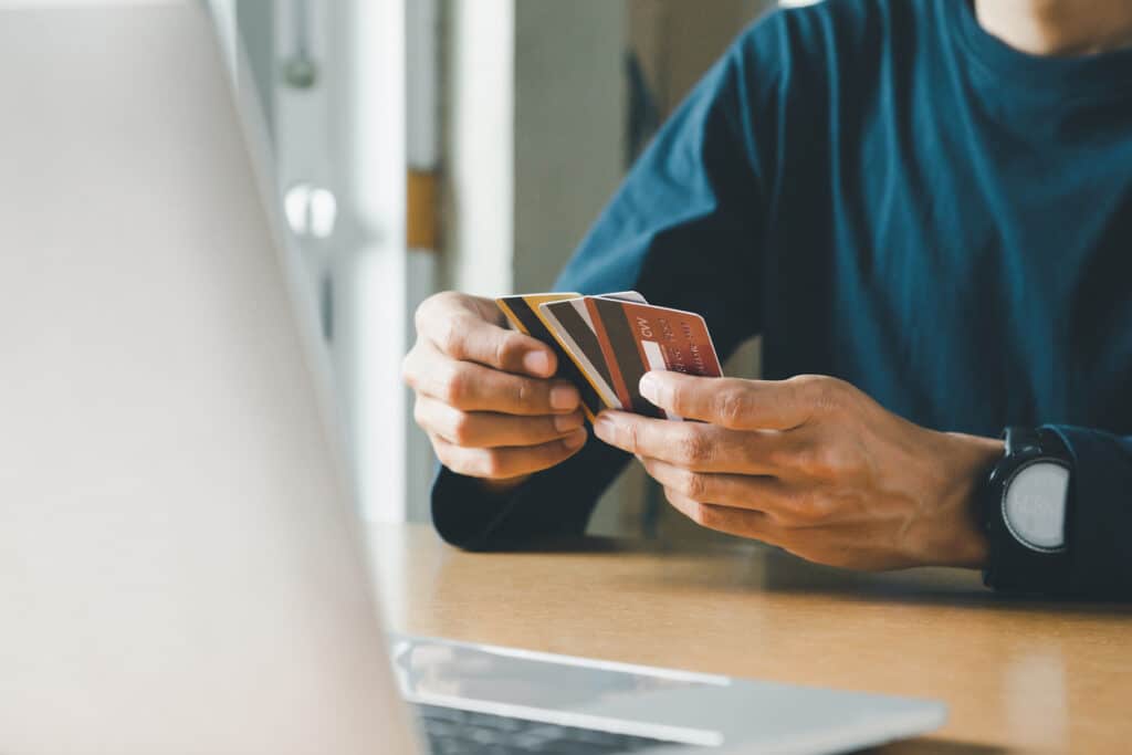 man holding unused credit card with three others