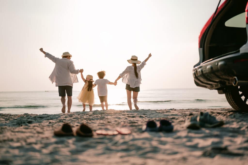 Summer vacation, family on a beach, back view, holding hands.