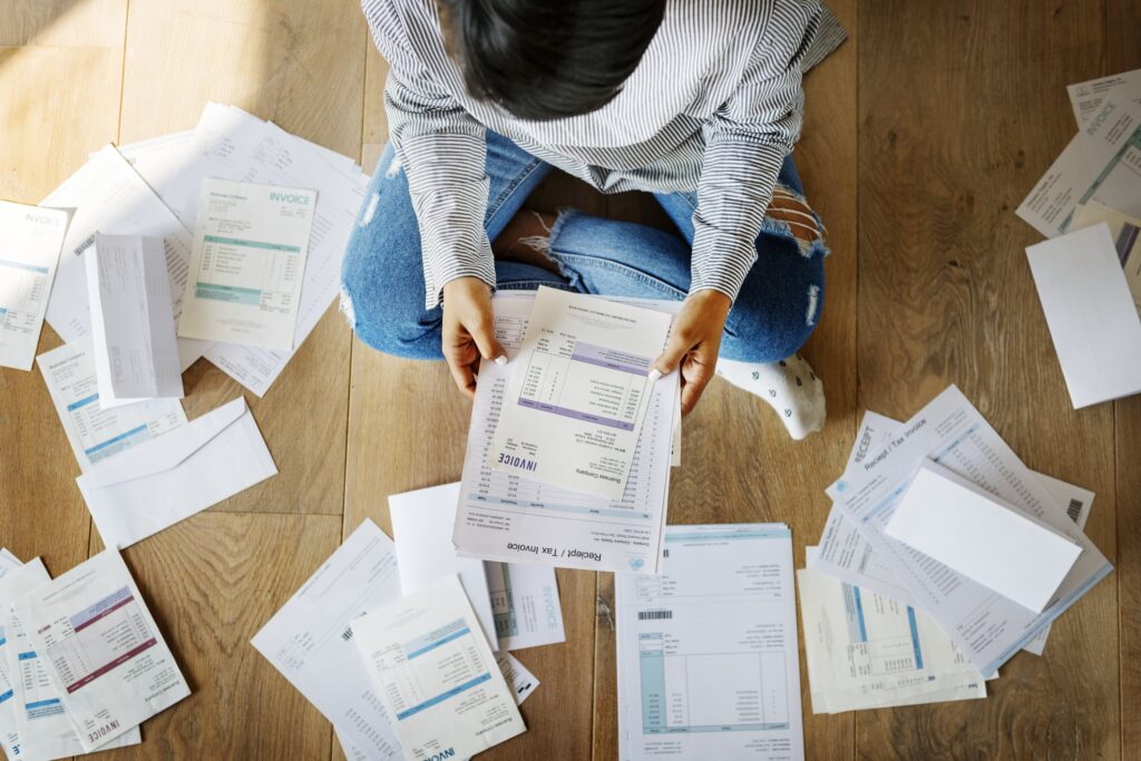 living expenses, person looking through stacks of paper.