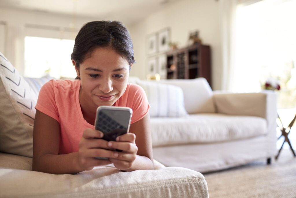 cell phone plans for kids—little girl using a cell phone.