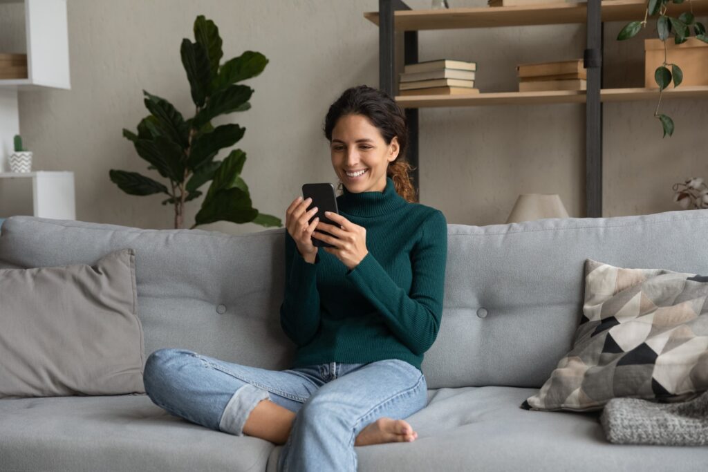 flash rewards user, woman smiling at phone on couch.