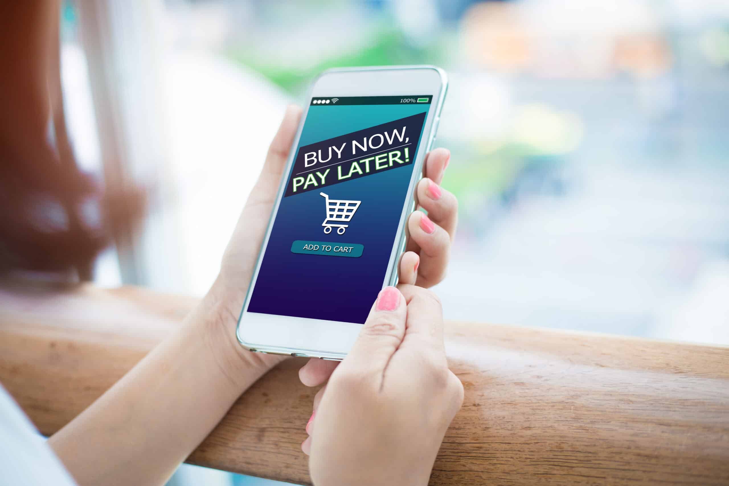 BNPL Buy now pay later online shopping concept. Hands holding phone.