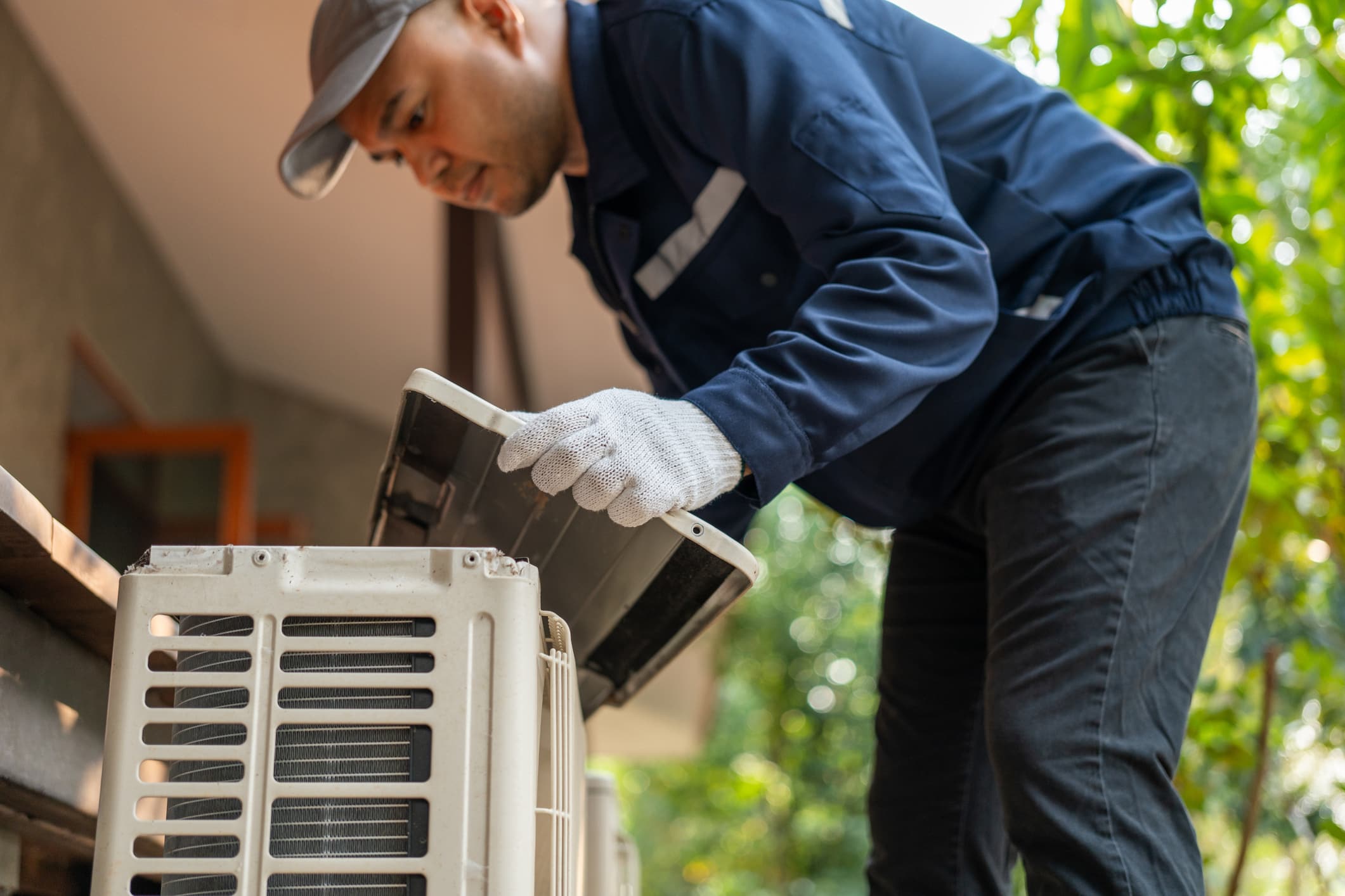 trade jobs—HVAC repairman looking at an air conditioner.