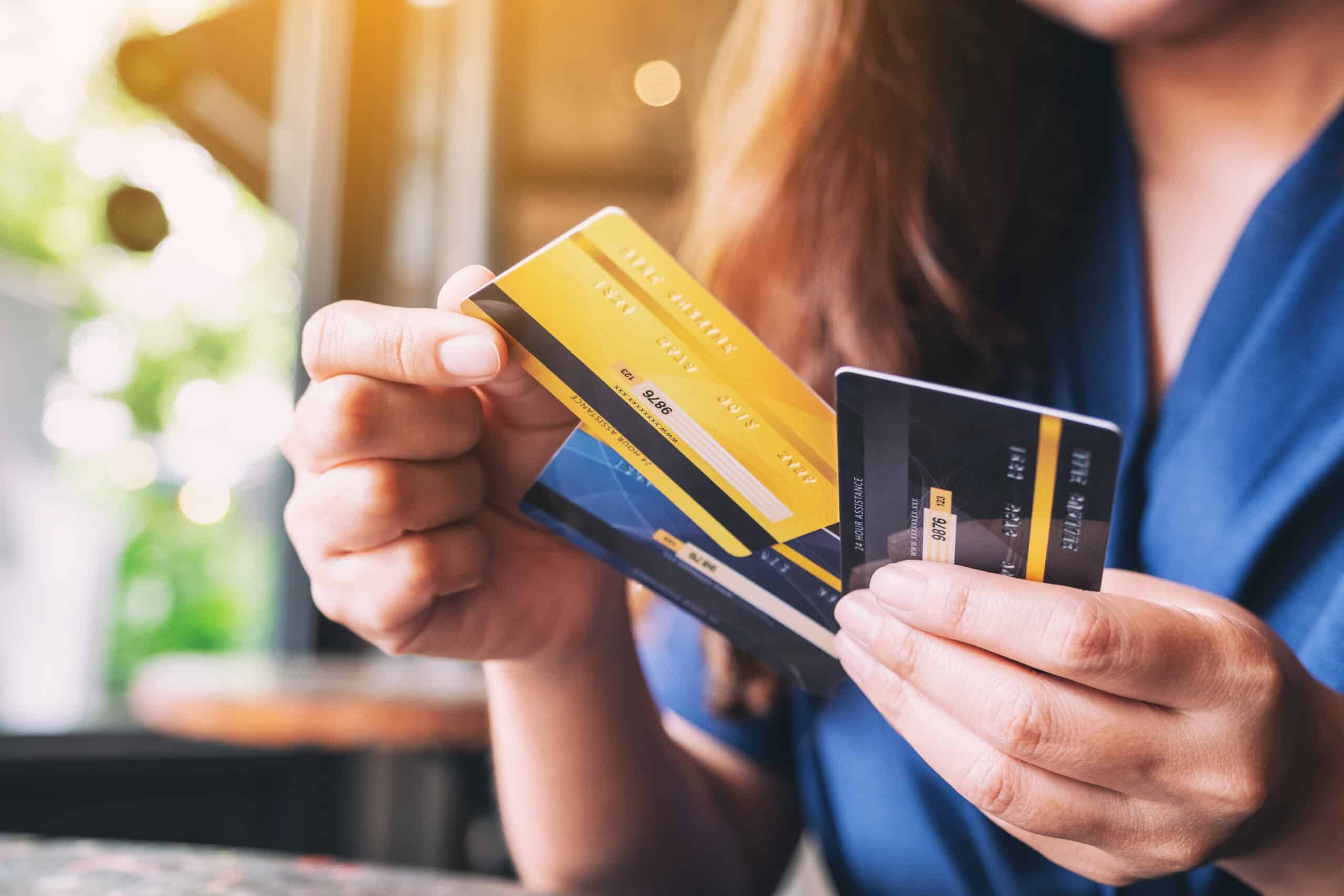 split payments: Closeup image of a woman holding and choosing credit card to use