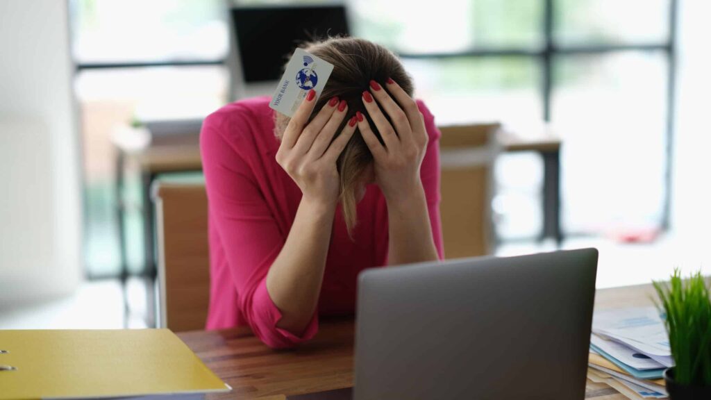 Overspending Worried woman having trouble shopping online using credit card and laptop. Theft of money from bank card in online network and cybercrime