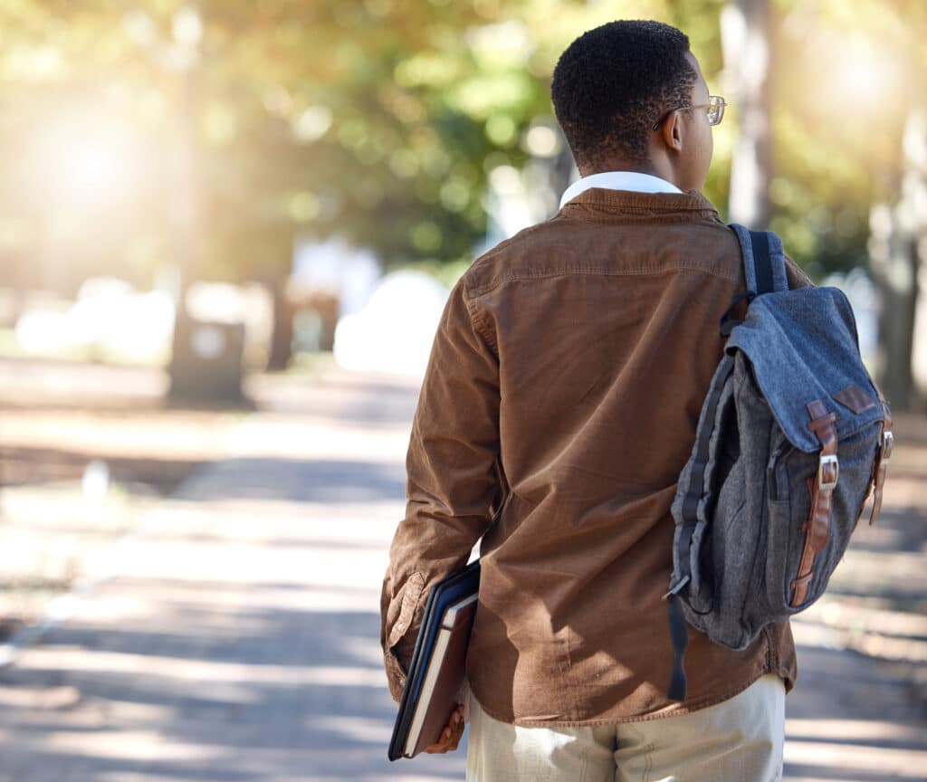 back to college. Black man, walking or backpack on campus, park nature or garden for college, university or school studying development. Student, gen z and person with learning books, education bag or growth mindset