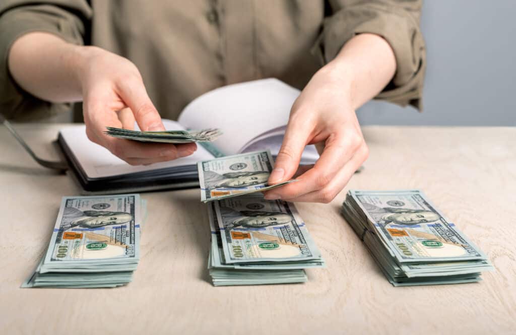 zero-based budget. person counting stacks of money.