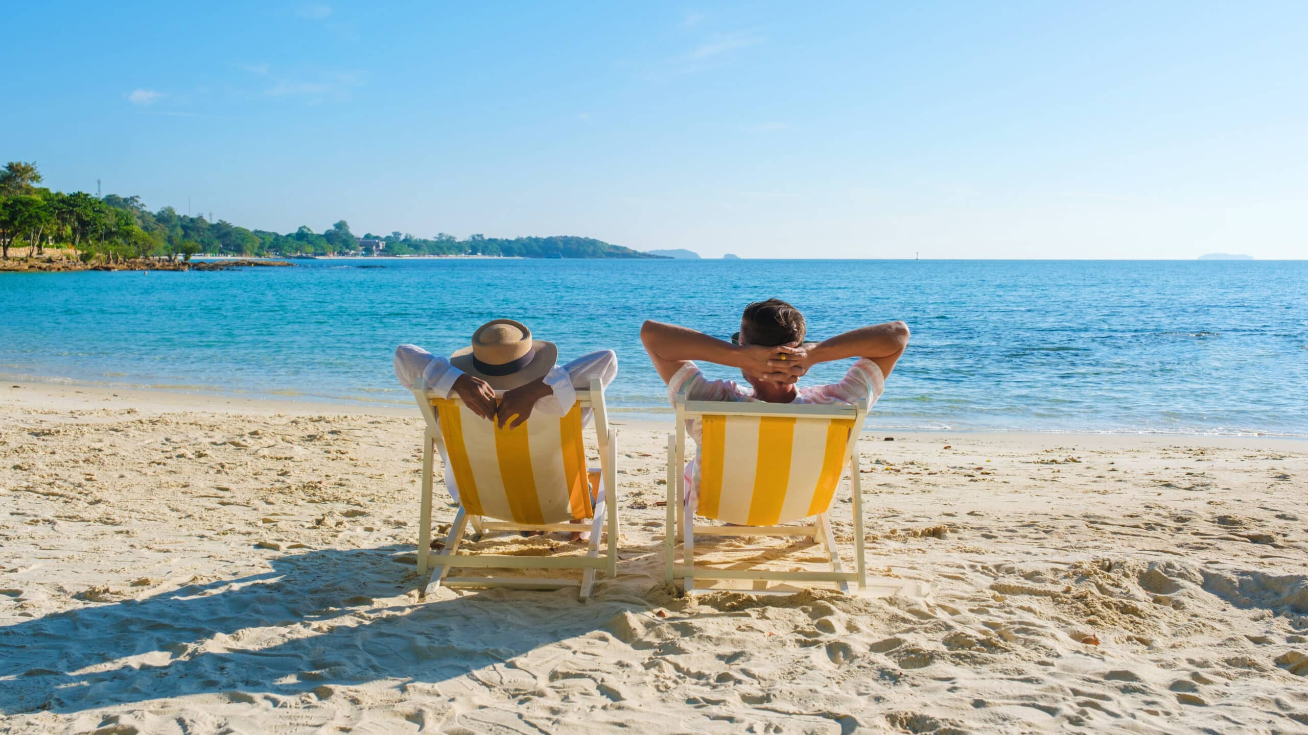 Budget for fun. couple in beach chairs, facing the ocean.