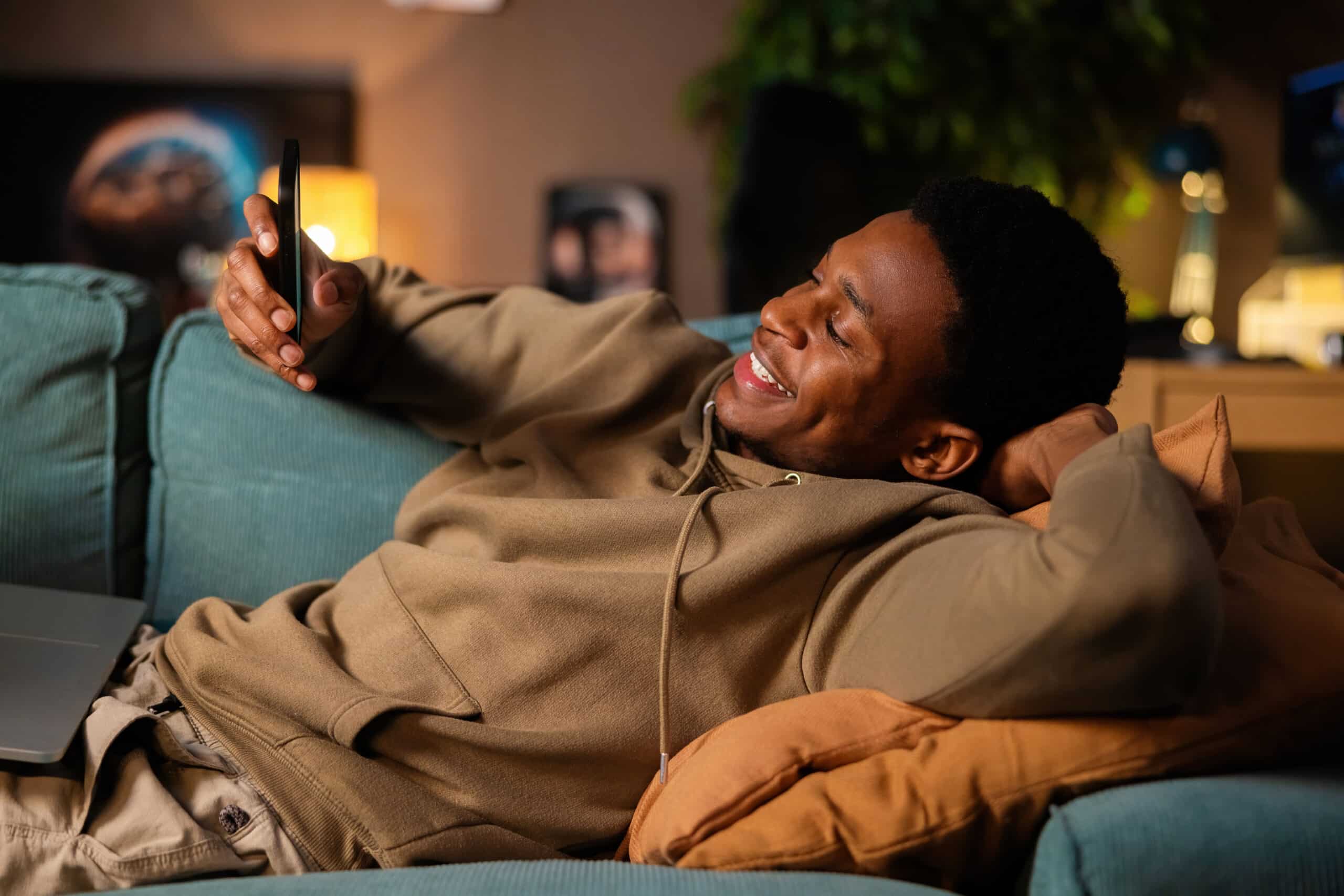 black friday. African American smiley sports enthusiast checking the latest scores and updates on his favorite teams.