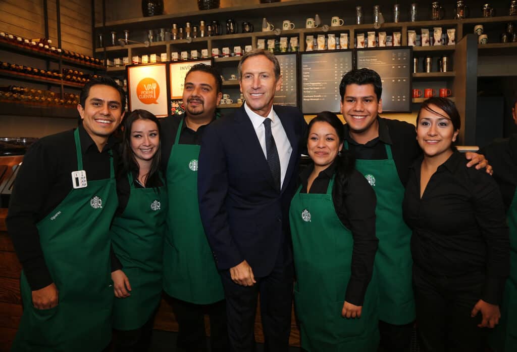 self-made: howard schultz standing with Starbucks employees