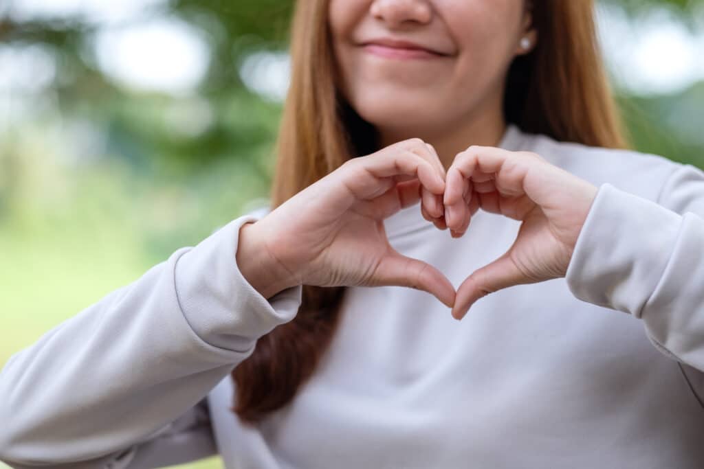 Love languages. Closeup image of a young woman making heart hand sign