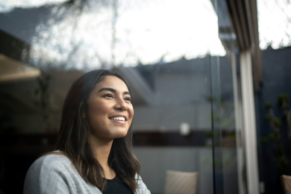 Financial wellness. Happy young woman contemplating at home