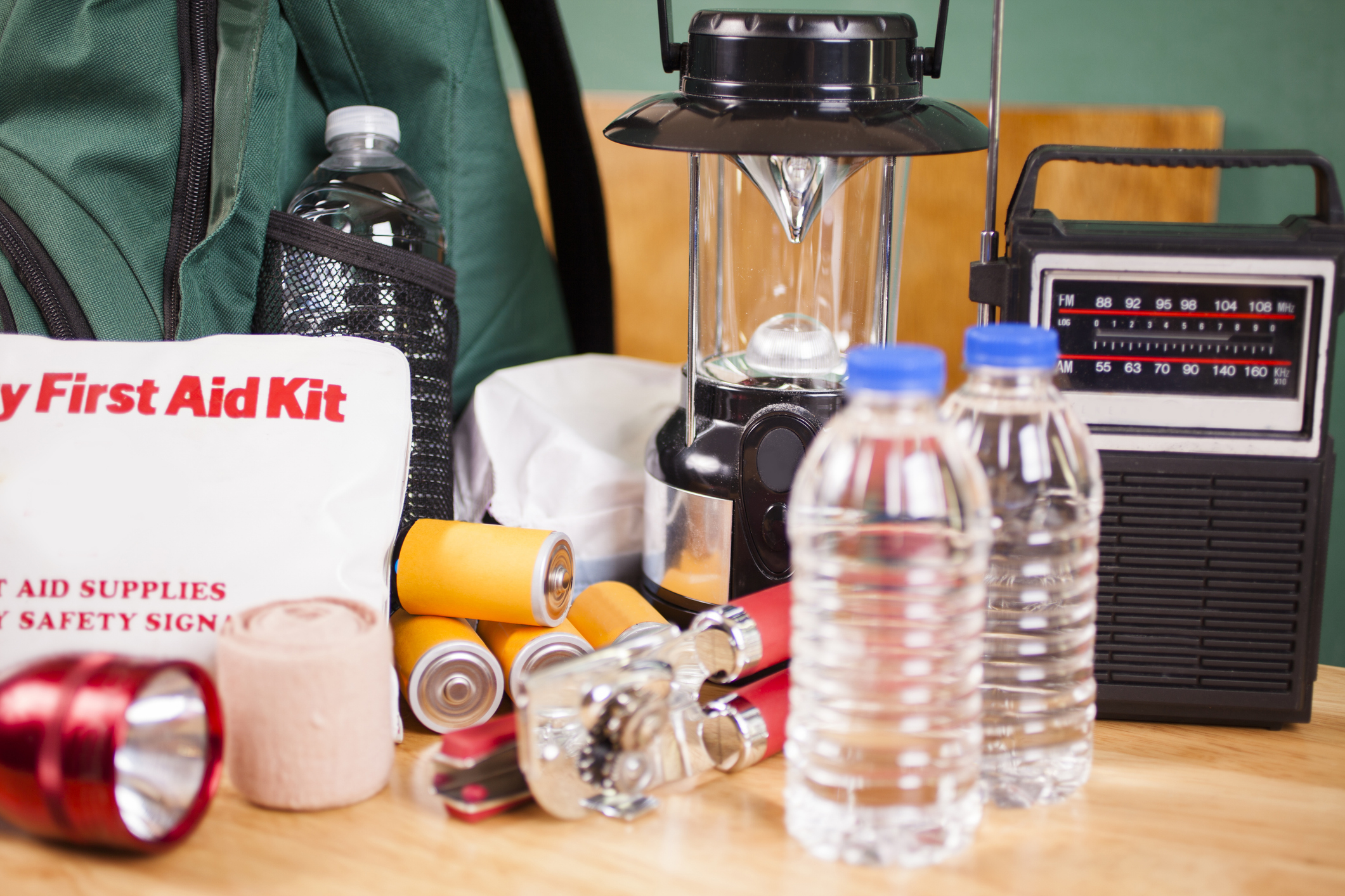 disaster. Emergency preparedness supplies. A large pile of supplies to be used in case of a natural disaster (hurricane, flood, earthquake, etc.) including: flashlight, backpack, batteries, water bottles, first aid kit, lantern, radio, can opener, mask. No people.